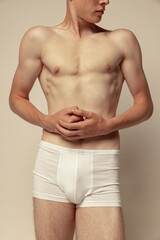 Obraz premium Cropped image of muscular male body in underwear isolated over grey studio background