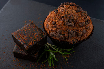 Chocolate cupcakes and chocolate candies on a black table. chocolate muffins. Cupcakes with chocolate sweet table