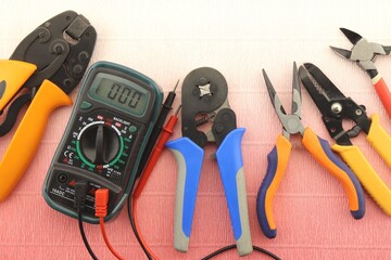 Multimeter and mounting tools on a color background close-up.