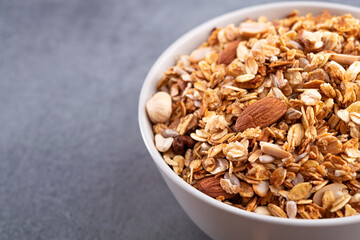 Fresh granola with almonds in a white bowl.