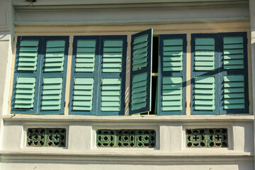 Detail of brown rectangular wooden windows of an old vintage shop house in the heritage town of Penang.