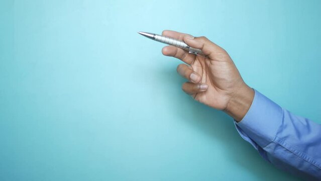 hand hols a pen against blue background 