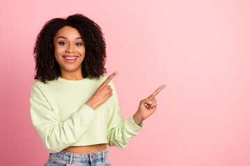 Photo of young cheerful woman indicate fingers empty space follow proposition discount isolated over pink color background