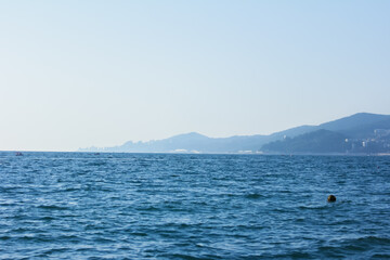 Minimalistic seascape, sea and mountains lost in a blue haze