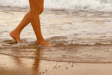 walking along the shore of the beach with the waves wetting your feet