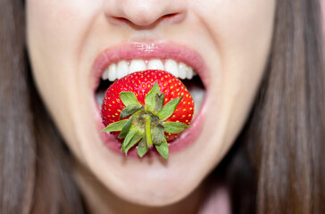 bitten red sweet tasty strawberry isolated on pink background in woman,girl hand. summer fruits concept. fresh food and drink. strawberry juice. mockup space for text. one big strawberry fruit