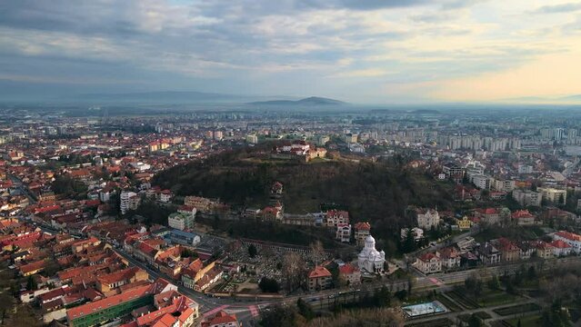 Aerial drone view of Barsov, Romania. The Citadel, medieval fortress on the top of a hill. Buildings around it, roads, greenery