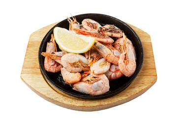 Fried shrimp with lemon. Serve in a cast iron skillet on a wooden board. Appetizing snack. Isolated on white background.