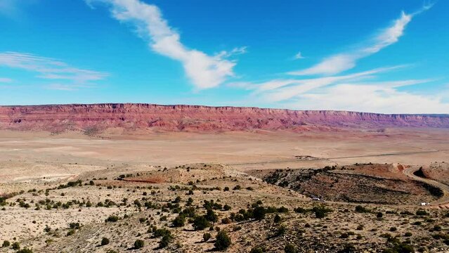 Vehicles drive scenic US Highway 89A with views of Vermilion Cliffs; drone