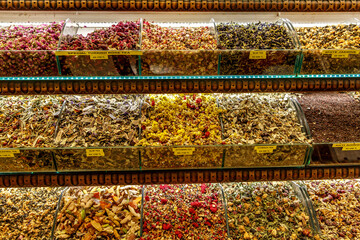 Market counter with different types of tea, herbs, plants, and dried flowers.