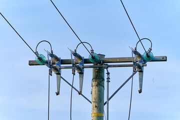 An old wooden electric pole power lines and wires with blue sky background