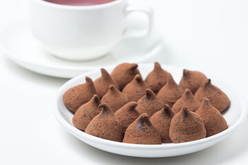 Chocolate truffle sweets on a saucer on a white background. Delicious chocolate dessert.