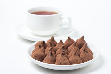 Chocolate truffle sweets on a saucer on a white background. Delicious chocolate dessert.