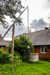 Fototapeta na wymiar old well with a crane in rural yard in Ukrainian village