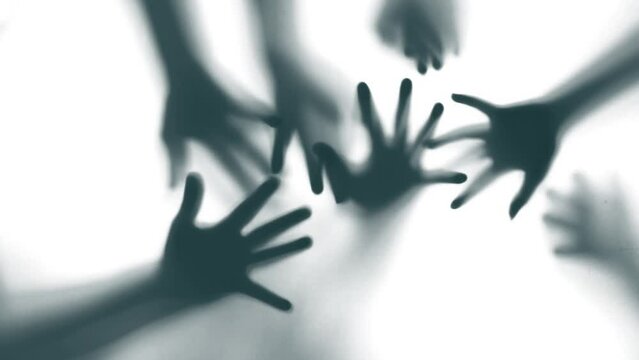 Shadow of a zombie hand on white background in slow motion
