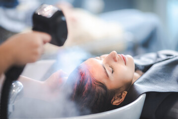 professional hairdresser woman are washing client hair in beauty salon, female head treatment and health care concept, person clean a hair by using water and shampoo to fashion hair care coiffure