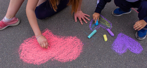 child's hand draws hearts, drawings chalk on asphalt - obrazy, fototapety, plakaty
