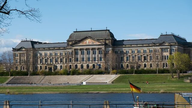 Dresden, Germany. Filmn&auml;chte am Elbufer, Festplatz an der Elbe. Powerful old building, german architecture Europe museum with summer and river on the foreground and flag on the boat.