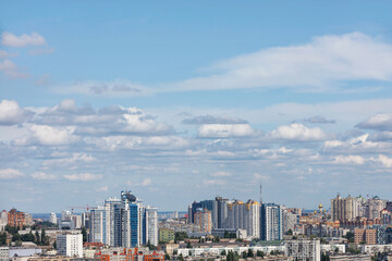 Fototapeta premium High sky with white clouds in the background of the urban landscape with new high-rise residential neighborhoods.