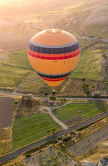 hot air balloon over agricultural fields in Cappadocia