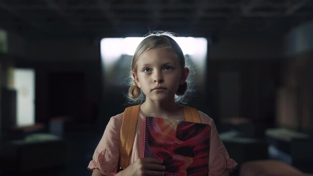 Schoolgirl holding books afraid to enter classroom closeup. Teen child standing.