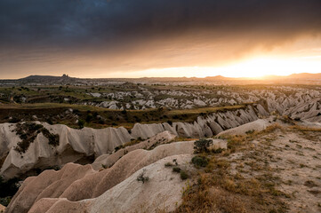 dramatic sunset and rainclouds over the desert of Cappadocia with Uchisar