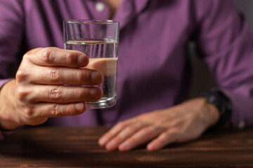 Man drinking from a glass of water. Health care concept photo, lifestyle, close up