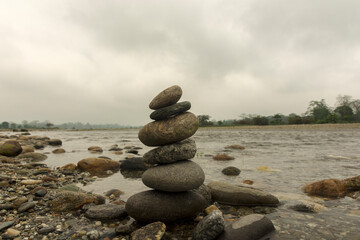 Pile of stones placed from smallest to largest one on top of the other beside Murti river a popular tourist destination in Dooars area West Bengal, India.