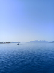 Landscape of the sea and an island with mountains and boats on the water. Beautiful summer photo