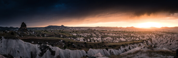 panorama with dramatic sunset and rainclouds over the desert of Cappadocia with Uchisar - obrazy, fototapety, plakaty