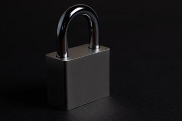 Steel padlock on the black textured background