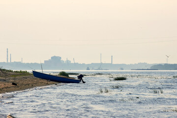 Fototapeta premium Fishing boat on the river bank on sunrise.