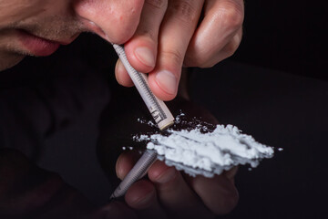 Concept drug addiction.. Drug abuse, man taking drugs, snorting lines of cocaine powder, close up - obrazy, fototapety, plakaty