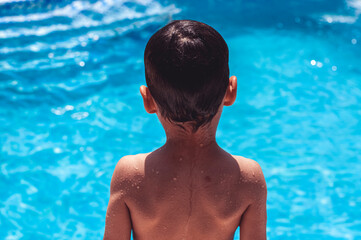 Behind shot of a boy in front of the pool before jumping