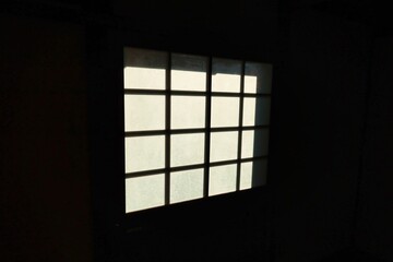 真っ暗な部屋の中から見えるすりガラスの窓