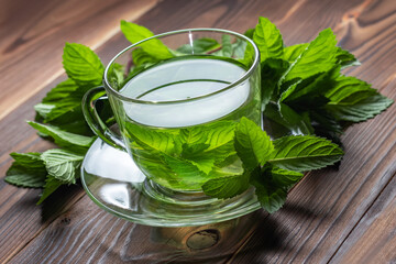 hot cup of tea with mint on wooden table