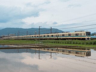 水鏡とアイボリー車体の電車
