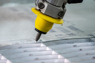 Close-up scene of multi-axis waterjet cutting machine cutting the aluminum plate.