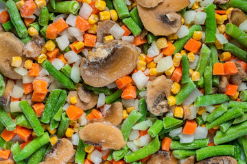 Chopped frozen vegetables background. Corn peas pepper carrots