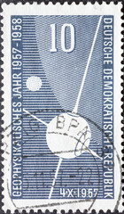 GERMANY, DDR - CIRCA 1957 a postage stamp from GERMANY, DDR, showing the earth satellite Sputnik 1 4.X.1957 in front of the earth and the moon. For the International Geophysical Year. Circa 1957