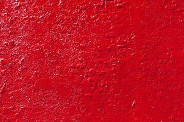 The red texture of old cracked paint. the scarlet wall is painted with paint. The background of a painted concrete wall. Industrial background