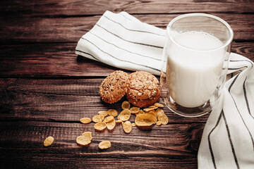 A glass of milk with cookie on a wooden background
