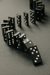 Black dominoes chain on dark table background