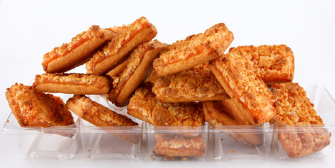 Orange cookies in a plastic container on a white background .