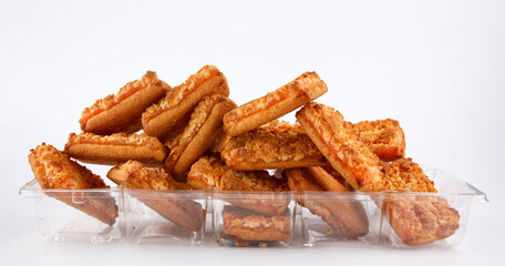 Orange cookies in a plastic container on a white background .