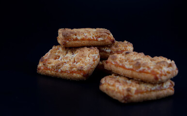 A few orange cookies on a dark background .