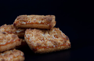 A few orange cookies on a dark background .