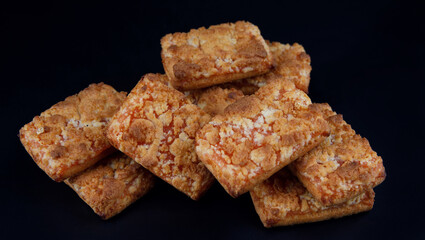 A bunch of orange cookies on a dark background .