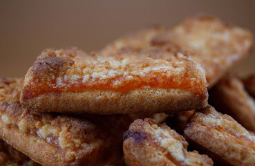 A bunch of orange cookies on a brown background .
