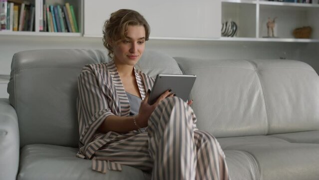 Woman surfing internet online at home interior. Surprised girl use pad computer